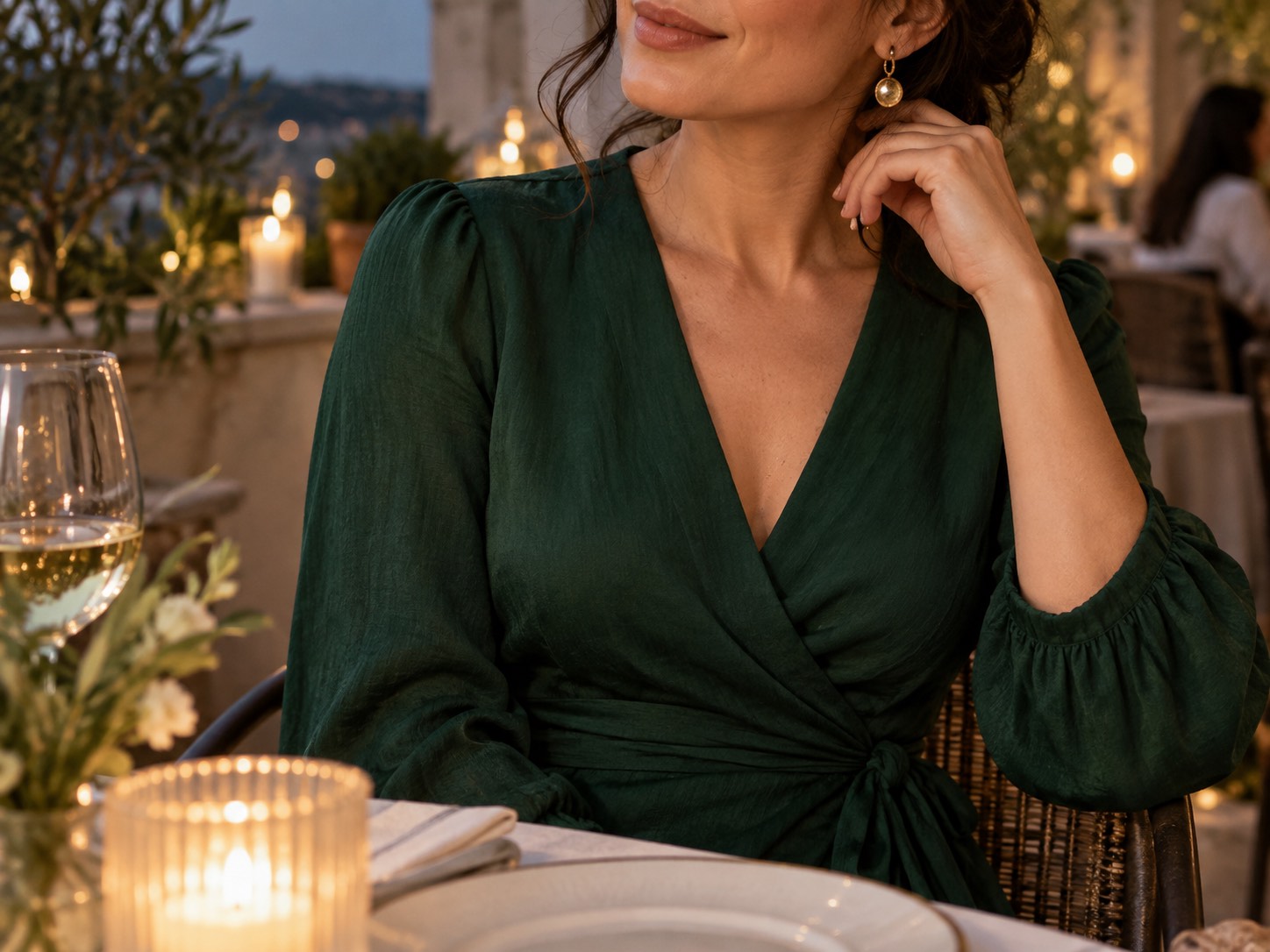 Detaliu: femeie la o aniversare în rochie petrecută midi verde închis, pe terasa unui restaurant